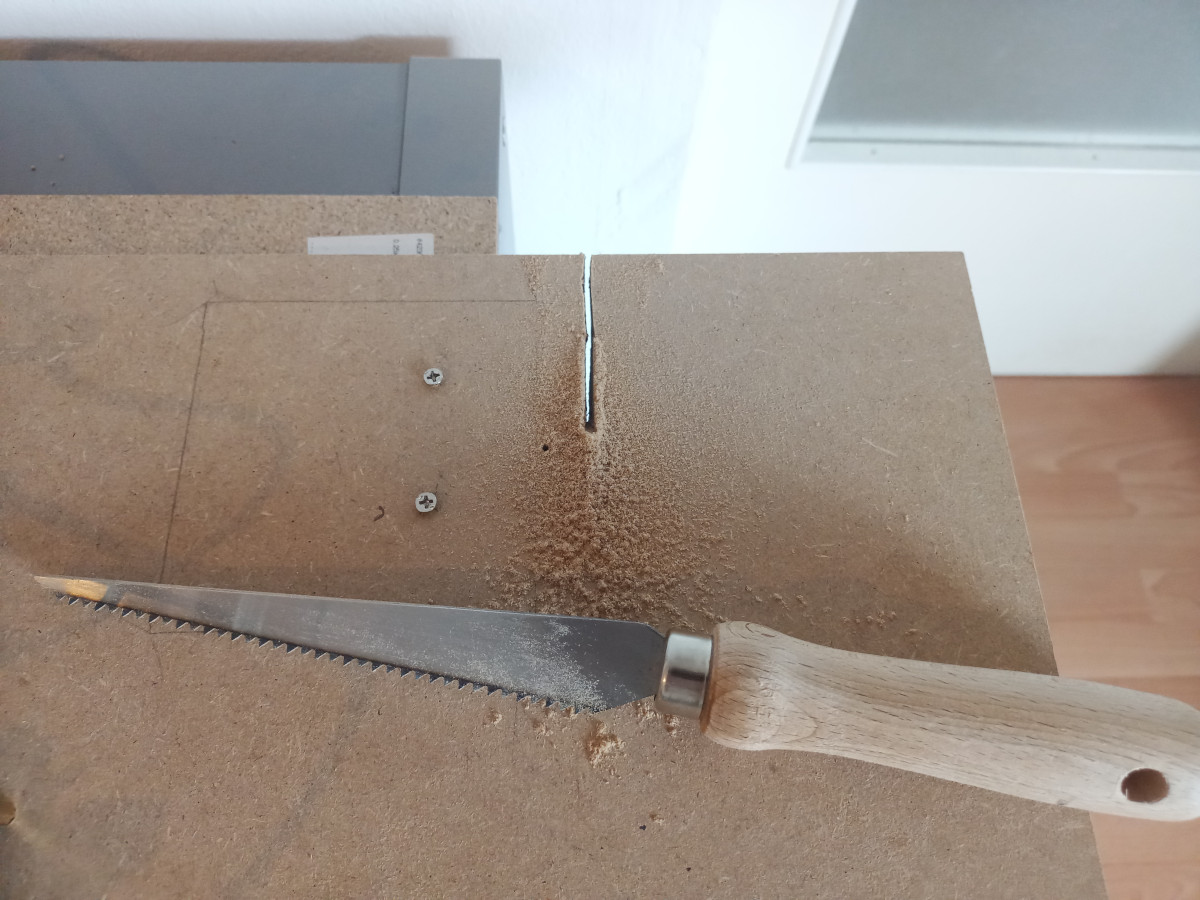 wooden board with 3 inch long cut and a small hand saw